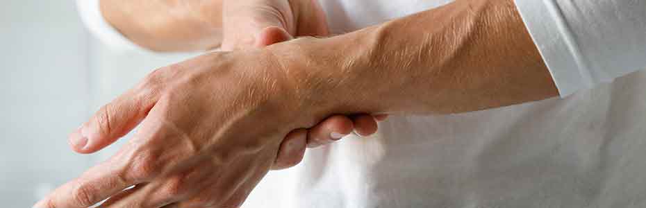 Homme souffrant d'arthrite qui se tient le poignet