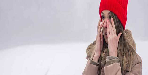 Woman experiencing nasal congestion out in the snow