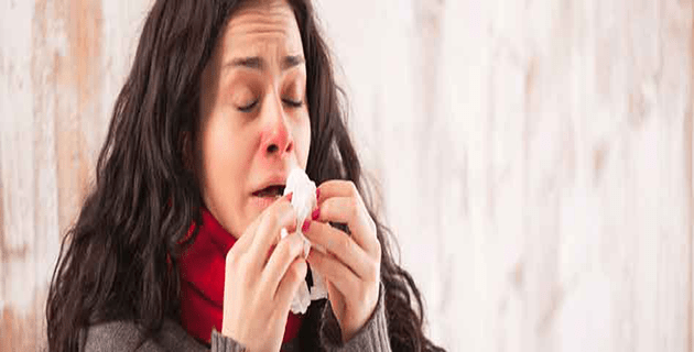 Woman about to sneeze into her tissue
