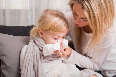 Jeune maman qui aide sa fille malade à se moucher